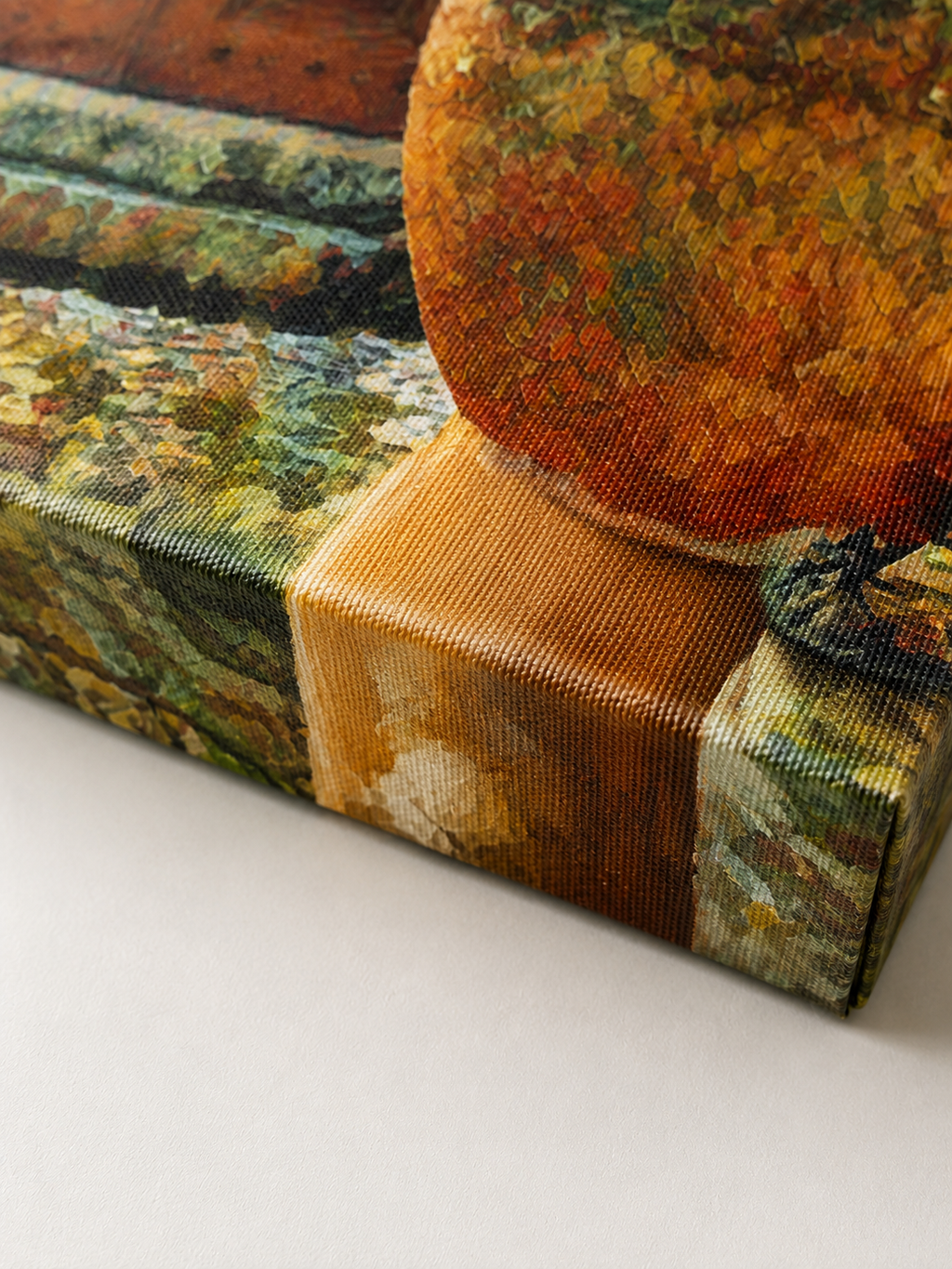 Close-up detail of a gallery-wrapped canvas print showing the woven canvas texture, crisp wrapped corner and printed edge in warm terracotta, ochre, green and stone tones
