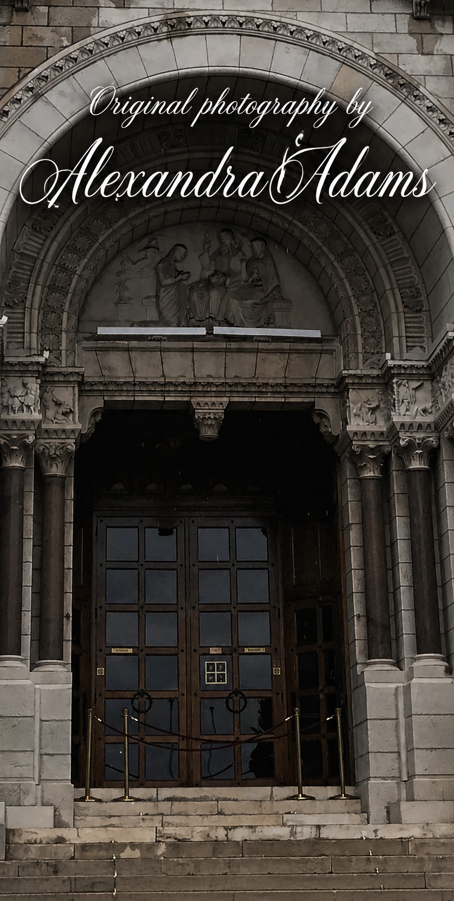 Original photograph by Alexandra Adams showing a grand historic stone entrance with deeply carved arches, sculpted figures, dark wooden doors and worn steps, with elegant bold white script photography credit across the upper arch
