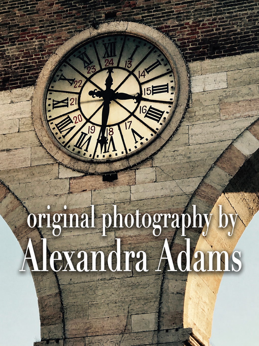 A square photographic print featuring a close-up of a stone clock face mounted on a brick and stone tower, with the text 'original photography by Alexandra Adams' overlaid across the lower portion.