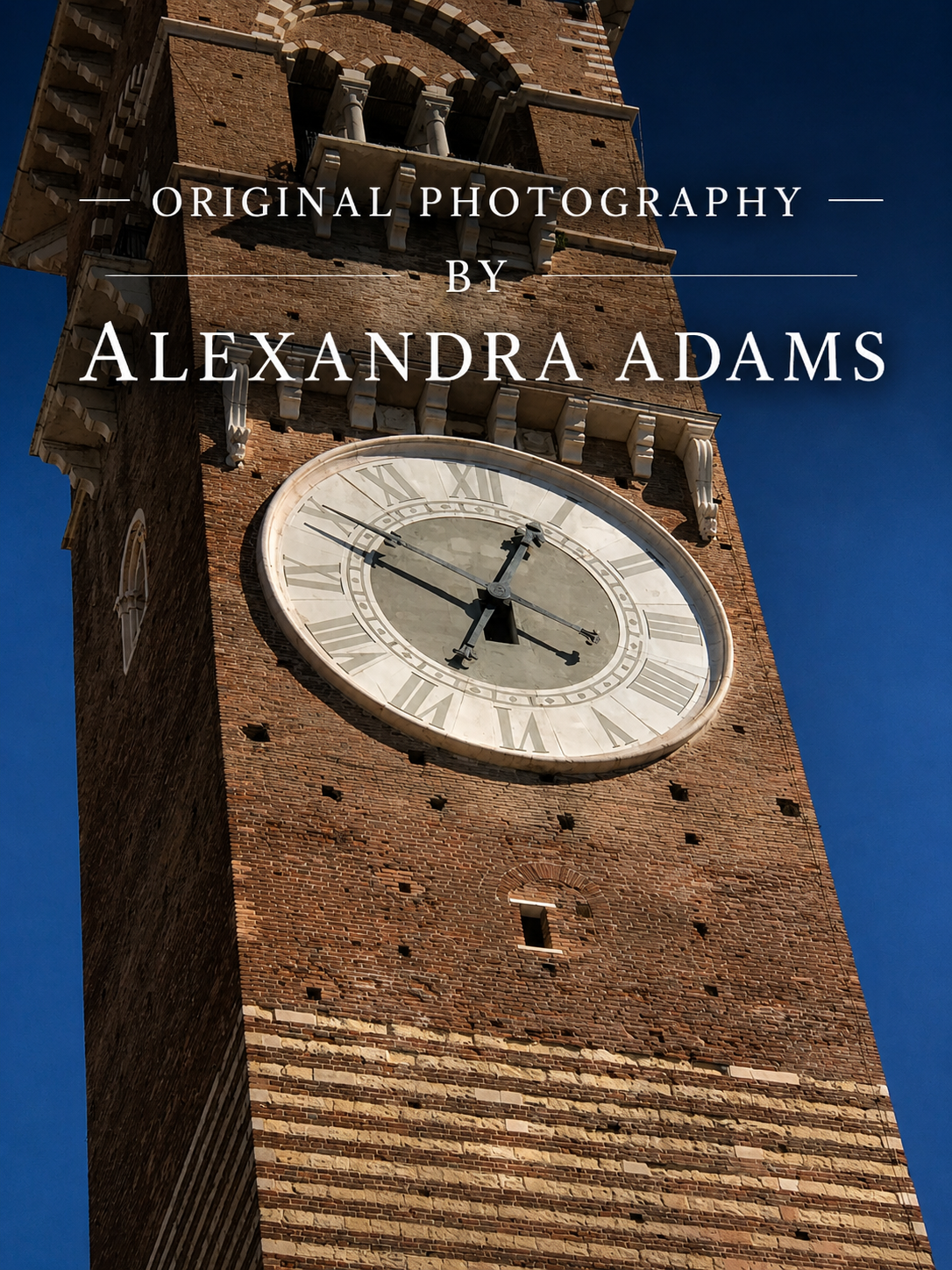 A low-angle photograph of a tall brick clock tower against a clear blue sky, with overlaid text reading 'Original Photography by Alexandra Adams.' The depicted scene itself appears to be the product, so this fits Scenery rather than Product/Packaging or Lifestyle.